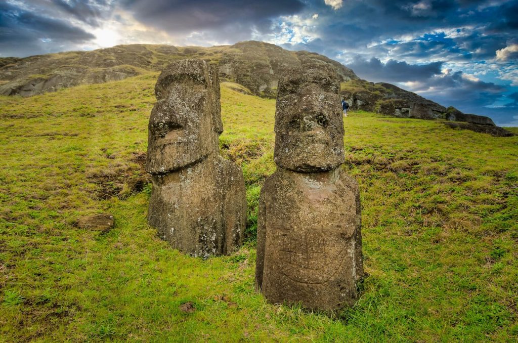 Dos estatuas de la Isla de Pascua sobre un fondo escénico