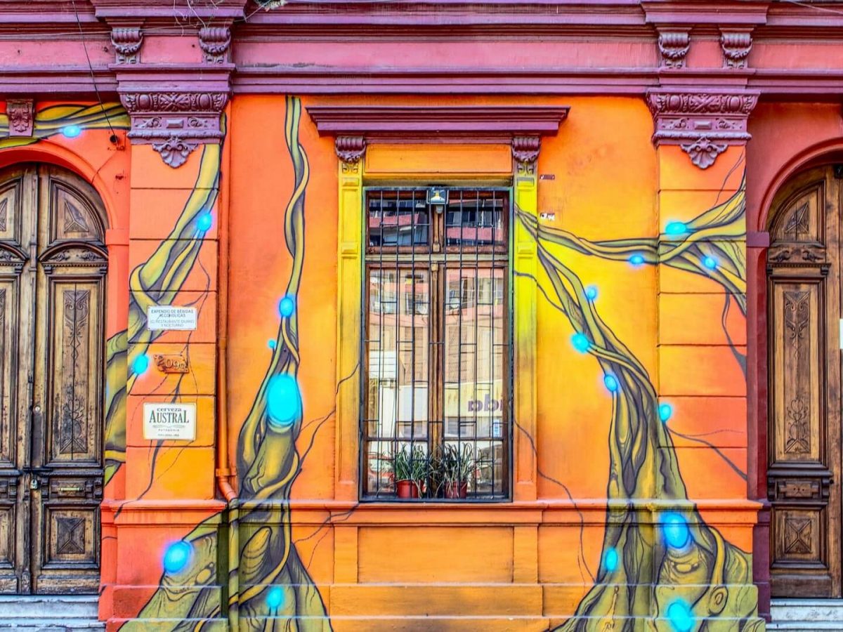 Colorido mural de arte callejero en Santiago de Chile, que representa vibrantes escenas urbanas.